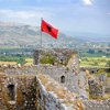 Red Albanian flag with double-headed black eagle waving over wall of Fortress Rozafa near Shkodra ci