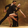 Dance ballroom couple in gold dress dancing on studio background.