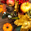 background with apples, golden and orange maple leaves, rowan and white berries on the wooden table
