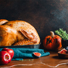 Festive table for Thanksgiving Holiday with whole roasted turkey with apple, pumpkin, figs and herbs