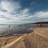 two people walk along the coast