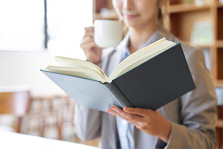 Asian woman reading at a cafe