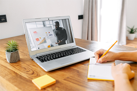 An African-American man conducts meeting on the laptop screen indoor