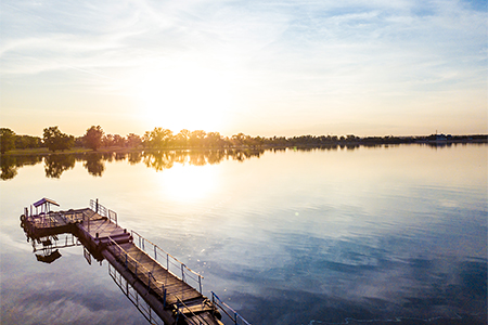 aerial view of pier on a lake during fantastic beautiful sunset in countryside