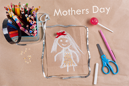 Child's drawing of mother; Background of old kraft paper, colored pencil, candy on a stick