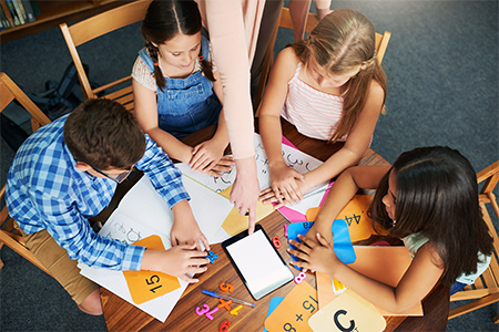 elementary students sitting on table learning