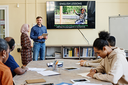 multi-ethnic group attending English language classes doing tasks during lesson