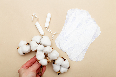 health care concept: Women's hygiene pads with tampons, flower cotton on a beige background