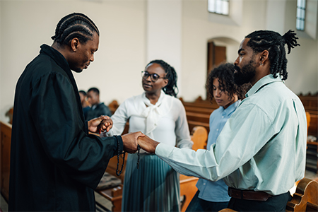 Priest praying with a family in church