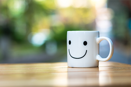 Happy cup on wood table with bokeh