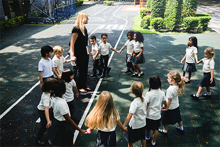 kids at elementary school playing with teacher