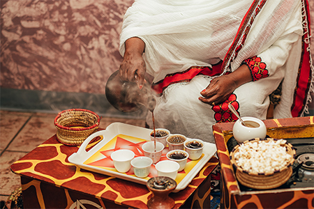 African woman making traditional coffee