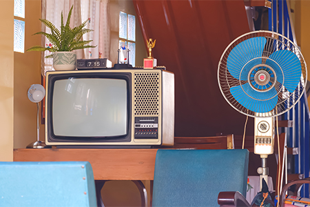 The old television and fan with household equipment in retro items inside of vintage house