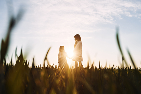 In beautiful sunlight. Majestic view. Two little girls have fun outdoors on the field at summer