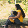 a woman drinking coffee in a white cup with her son in a natural environment
