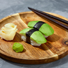 Sushi covered with avocado on wooden board gray stone background