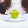 tape measure coiled around an apple on white plate