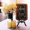 Welcome home chalkboard sign on the table with white flowers