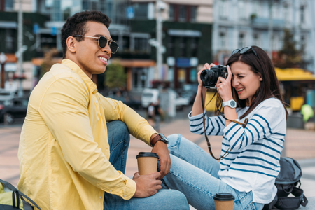 Woman sitting and taking photo of an Asian man