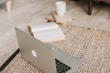 Laptop and books on floor carpet