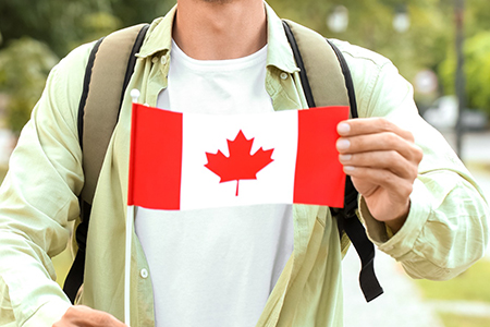 Male tourist with flag of Canada in park