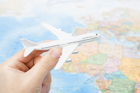 Toy plane in hand with world map on background