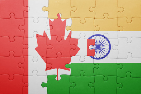 canada and india flags intertwined puzzle pieces