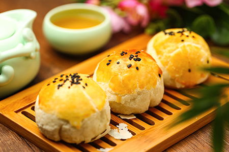 egg yolk puff and tea on bamboo plate