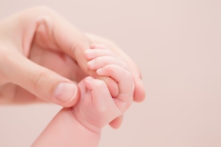 close crop of mother hand and baby hand