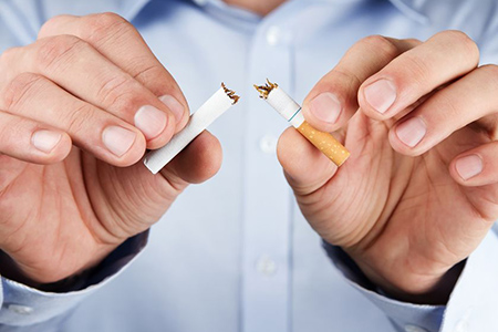 Quit smoking, human hands breaking up cigarette