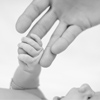 Newborn baby with mother's hand. Black and white photo.