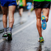 Marathon running race, people feet on city road in wet rain