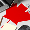 Canada national flag on top view work space of creative designer with laptop, computer keyboard, usb