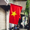 A scenic view of the Vietnamese flag hanging outside of a store