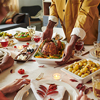 Hands of a person serving roasted turkey to diverse group of adults sitting around Thanksgiving dinn