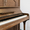 A close shot of an old wooden piano with a blurred background