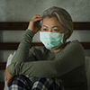 worried middle aged woman 50s with grey hair and protective mask during covid-19