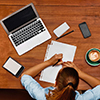 woman at desk with laptop and notebook