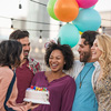 Friends celebrating birthday party on rooftop with birthday cake