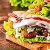 Falafel and fresh vegetables in pita bread on dark background.