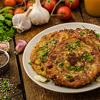 Fried potato pancakes with garlic and marjoram, sprinkled cumin, chive and coarse-grained salt