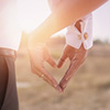 bride and groom forming heart with hands