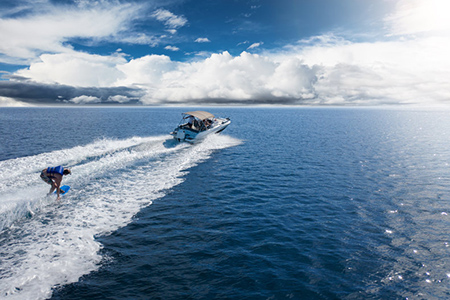 Speedboat with wakeboard rider on open sea