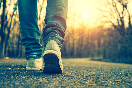 cropped image of walker's shoes on pavement