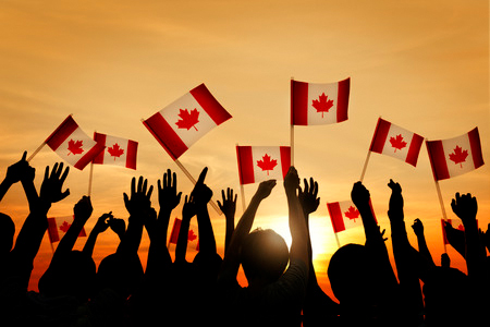 silhouette of group of people holding canada flags