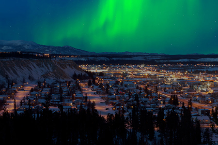 Strong northern lights Aurora borealis substorm on night sky over downtown Whitehorse, capital of th