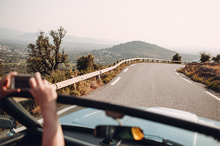 Long and winding asphalt road leading through hills