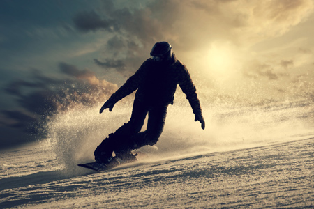 Snowboarder slides down the snowy hill