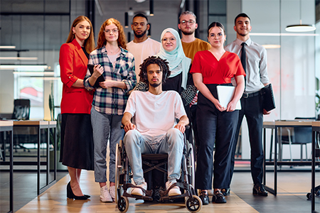 A diverse group of young business people walking a corridor in the glass-enclosed office