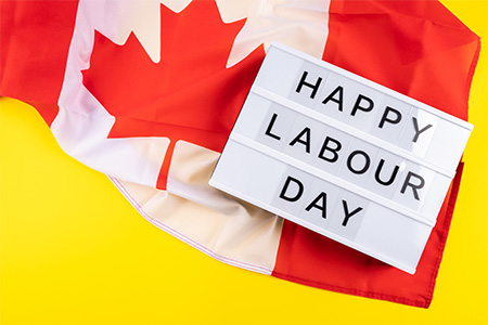 Labor Day greetings text on lightbox on yellow background with Canadian flag